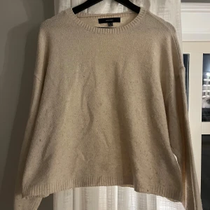 Beige stickad tröja  - Mysig beige stickad tröja med rund halsringning och avslappnad passform. Perfekt för lager-på-lager och passar till allt. Ribbstickade muddar vid ärmslut och nederkant ger en snygg detalj.