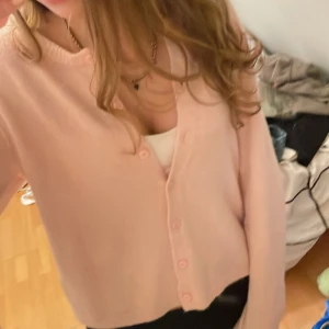 Ljusrosa kofta  - Supersöt ljusrosa kofta från lager157 med rund halsringning och knappar framtill. Koftan är i mjuk stickad bomullsblandning och har långa ärmar. Perfekt att slänga över ett linne eller t-shirt för en chill look.