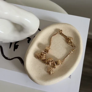 guld armband med rosa detaljer  - bra stick