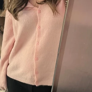 Ljusrosa kofta med knappar - Superfin ljusrosa kofta med klassisk krage och matchande knappar framtill. Mjuk och fluffig känsla, perfekt för lager-på-lager. Långärmad och lätt oversized passform som ger en chill vibe.