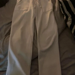 Vita mjukisbyxor med snörning - Vita mjukisbyxor med raka ben och resår i midjan samt snörning. Byxorna har två fickor framtill och är tillverkade i mjukt material, perfekta för chill dagar. Enkel och clean look som passar till det mesta.