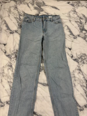 Ljusblå raka jeans från Monki - Ljusblå jeans från Monki med klassisk femficksdesign och raka ben. Jeansen har hög midja och är tillverkade i bomull med synliga kontrastsömmar. 