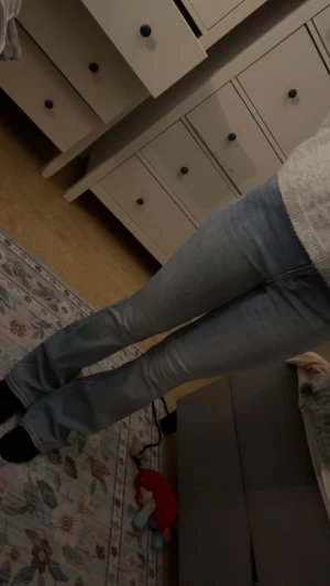 Bootcut ljusblå jeans  - Säljer ett par ljusblå jeans med bootcut passform. Jeansen har klassisk femficksdesign och är tillverkade i mjukt denimtyg som sitter snyggt över benen och släpper ut vid anklarna. Perfekt för dig som gillar en retro vibe och vill ha ett par jeans som sticker ut.