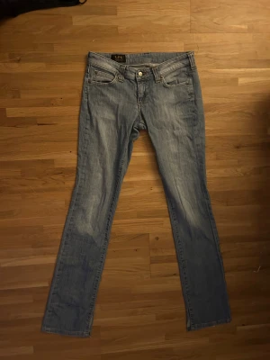 Snygga lowrise blå jeans - (Ljus-ish) blåa, bootcut, lowwaist jeans från Lee.  Midjemått: 37cm, passar mig som är 172cm i längd (men kan nog passa både längre och kortare oxå!). Köptes för runt 400kr. 