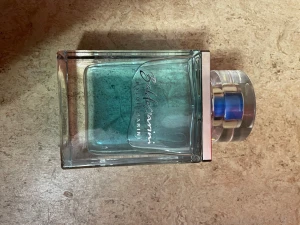 Baldessarini fräsch parfymflaska - Stilren parfym från Baldessarini med blågrön vätska och modern design. Perfekt för dig som vill sticka ut med en fräsch känsla. Passar dig som gillar exklusiva detaljer och vill ha något unikt i samlingen.