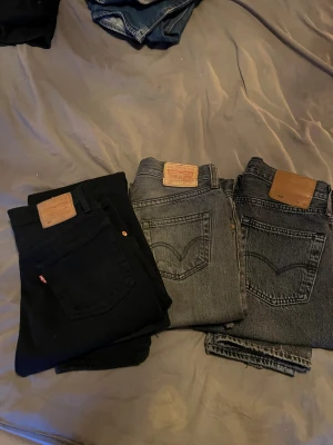 Levi’s 501or strl 28-27 - Säljer tre par Levi’s-jeanss i bra skick, svarta 500kr strl w27 L26,    ljus grå 200kr w25,    mörk 500kr grå w28 L32  **Alla är äkta Levi’s och säljs tillsammans 1200kr eller styckvis**Byxorna är använda men väl omhändertagna, inga hål eller större slitningar. Perfekt för dig som vill ha klassiska och stilrena jeans i bra kvalitet.
