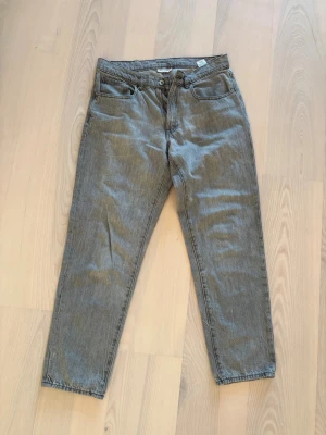 Grå jeansbyxor från Vailent, M - Snygga grå jeansbyxor från Vailent i modellen 'Skate Grey Stone'. De har klassisk femficksdesign, rak passform och normal midja. Materialet är slitstarkt denim och färgen är stengrå med en cool tvättad look. Perfekt för dig som gillar streetwear och avslappnad stil.