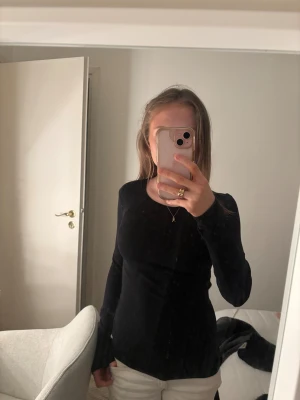 Svart långärmad topp - En svart, ribbad långärmad topp från FSBN Sister i storlek S. Tröjan sitter åt det tajtare hållet med rund halsringning och stretchigt material som sitter snyggt på kroppen. Perfekt att styla med jeans eller kjol för en clean look. 