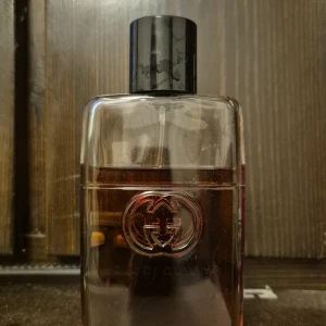 Gucci Guilty parfymflaska - Stilren parfym från Gucci med den ikoniska GG-loggan på flaskan. Perfekt för dig som vill ha en lyxig touch i din doftsamling. Volym och ingredienser syns ej på bilden.