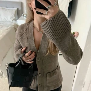 Beige stickad kofta med knappar - Säljer en beige stickad kofta med breda ribbade muddar och v-ringad hals. Verkligen jätte fin och perfekt för vintern! Obs lånad bild original pris:899. Pris kan diskuteras.