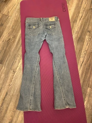 True Religion bootcut jeans blå - Säljer ett par snygga blå jeans från True Religion med bootcut passform. Storlek W27, kom gärna med frågor eller prisförslag. nypris 1 299kr