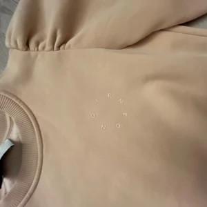 Beige sweatshirt från Neo Noir - Snygg beige sweatshirt från Neo Noir med rund hals och ribbade muddar vid ärmslut och hals. Tröjan har ett diskret tryck med bokstäver på bröstet. Helt oanvänd! Nypris 500kr