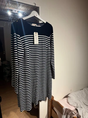 Randig marinblå klänning från Lindex - Snygg randig klänning från Lindex i marinblått och vitt. Prislappen sitter kvar!