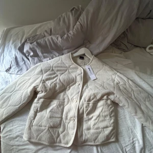 Beige quiltad jacka från Gina Tricot - Quiltad beige jacka från Gina Tricot med stora fickor framtill och knäppning med fyra knappar. Helt oanvänd med lappen kvar💕
