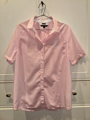 Tommy Hilfiger blus - En oanvänd rosa blus från Tommy hilfiger. Tunt material som är perfekt om du vill ha den över något annat plagg. Stilren logga på framsidan. Storlek XL vilket gör den perfekt att använda över  till exempel en topp eller T-shirt. 