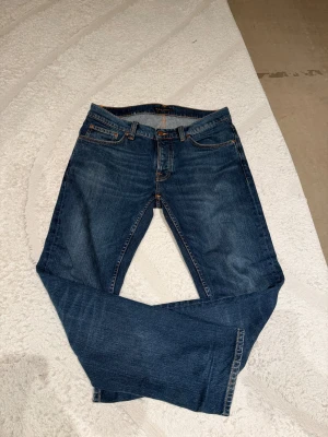   Nudie Jeans Co - Snygga blå jeans från Nudie Jeans. Ny skick använd fåtal gånger. Modellen heter solid ollie och är straight fit. Snygga nu med mörkare jeans mot vintern. Ny pris 1800kr. Pris kan diskuteras vid snabb affär.