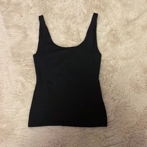 Figursydd svart topp från HM - En helt vanlig svart figursydd topp i storlek XS från HM, använd ett fåtal gånger men inga tecken på fläckar eller skador. Kontakta vid intresse eller annat och vid köp välj helst postnord, blir lättast att frakta för mig!