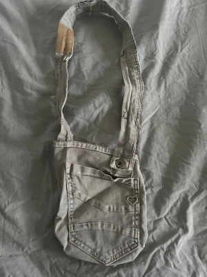 Grå axelväska med hjärtdetalj - En egengjord väska av ett par ljusgrå jeans🩶🤍