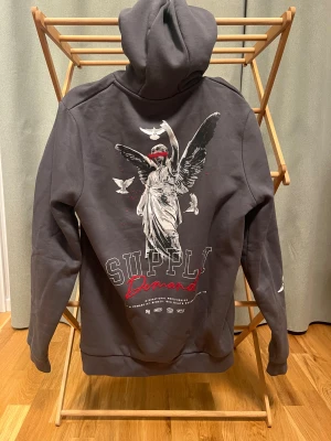 SUPPLY Hoodie med tryck - SUPPLY hoodie i grå färg med feta tryck, är i jättefint skick och knappt använd, Storlek: S