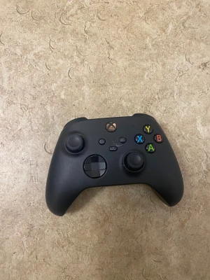 Xbox Series Wireless Controller - Snygg svart Xbox Series Wireless Controller i gott skick. Alla knappar och joysticks fungerar som de ska. Passar Xbox Series X/S och PC. Inga synliga repor eller skador, endast lättare bruksspår. Perfekt för gaming med trådlös anslutning och ergonomisk design.