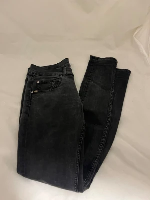 Svarta slim jeans tiger of sweden - Svarta jeans med slim fit och klassisk femficksdesign från tiger of Sweden. Jeansen har en snygg tvättad look och raka ben, med knapp och dragkedja i midjan. Passar dig som gillar en smalare siluett och stilren vibe.