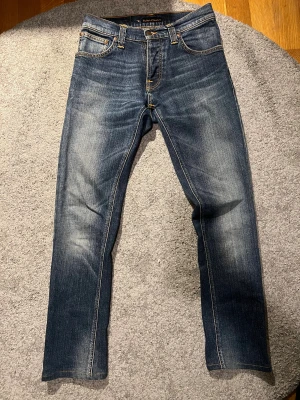 Nudie Jeans grim Tim  - Säljer dessa grim Tim’s med sjukt snygg wash. Paret är en storlek W30. De är uppsydda så längden är drygt L31/32