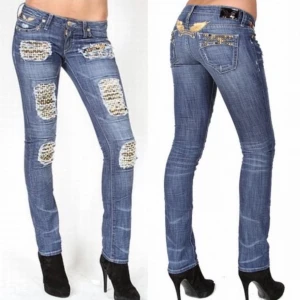 Robin jeans med nitar och slitningar - Säljer ett par blå jeans från Robin's Jean med grova slitningar och svarta detaljer under hålen. Jeansen har silverfärgade nitar på fickorna och broderade vingar baktill. Modellen är rak med lowaist passform och midja. 