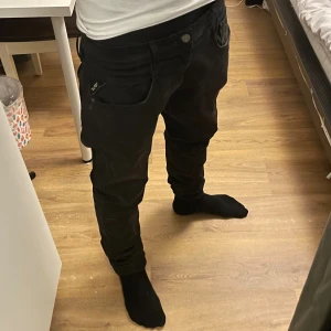 Svarta Replay Hyperflex jeans, W32 L34 - Säljer ett par svarta Replay Hyperflex jeans. De har en slim passform med klassiska fem fickor, snygga detaljer och stretchigt material som gör dem riktigt sköna. Perfekta om du gillar stilrena och bekväma jeans med modern look.
