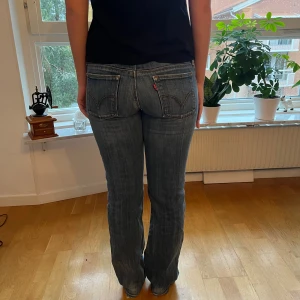 Levi's 570 blå jeans bootcut - Säljer ett par klassiska Levi's 570 jeans i blå tvätt med bootcut-snitt. De har fem fickor, låg midja och snygga slitningar för en cool look. Materialet är robust denim och passformen är loose. Perfekta för dig som gillar retrostil och vill ha bekväma jeans. Passar dig med storlek S eller 36/38