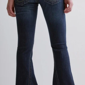 Mörkblå true religion jeans - Snygga mörkblå jeans från true religion med bootcut-passform. Jeansen. Jeansen är mid waist och perfekta i benen för mig som är 172