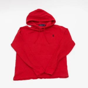 Röd hoodie från Polo Ralph Lauren - Riktigt snygg röd hoodie från Polo Ralph Lauren med klassisk huva och dragsnören. Tröjan är stickad i bomull och har det ikoniska broderade logot på bröstet. Perfekt för dig som gillar en chill och stilren look.