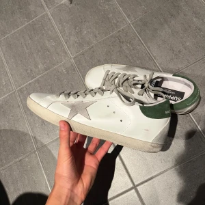 Golden goose skor med grön häl | storlek 42  - Tjaba! Säljer nu mina golden goose superstars i storlek 42. Skorna är i toppskick utan deffekter eller likande 😄! Dustbag tillkommer och orderbekräftelse finns. Hör av dig vid frågor eller funderingar! 