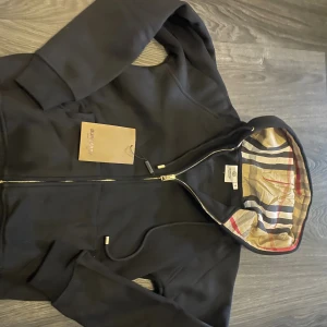 Svart Burberry Zip Hoodie - Storlek M, Men är som storlek S, Helt Ny, kom privat för frågor, disskuterar helst mått så allt går rätt till