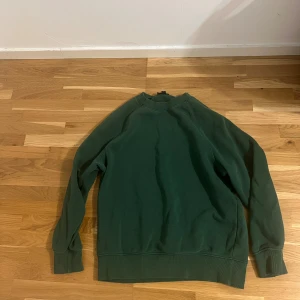 Mörkgrön oversized sweatshirt H&M - En mörkgrön oversized sweatshirt från H&M med klassisk rund halsringning och ribbade muddar vid ärmslut och nederkant. Tröjan är enkel och stilren, perfekt för en chill och avslappnad look. Materialet är mjuk bomullsmix som känns skön mot huden.                         Den passar till både M och S men är i storlek S
