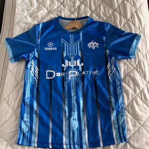 Marseille Toto et ninetta Jul Yamaha - En blå sällsynt tröja från Yamaha och JuL. Perfekt tröja för sommaren. Använd bara denna sommarn och har inga tecken på användning. Nypris ca. 900kr