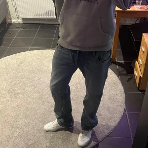 Ljusblå jeans Diesel  - Säljer ett par klassiska blå jeans från Diesel Industry med snygg tvätt och raka ben. Jeansen har fem fickor, diskreta slitningar och tydliga sömmar. Märkespatch bak i midjan och cool vintagekänsla. Perfekta för dig som gillar en tidlös denimlook.