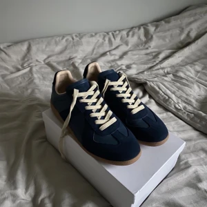 Maison Margiela GATS - Nu säljer jag ett par stilrena mörkblåa GATS i storlek 45, skicket är 9/10, boxen och dustbags ingår, skriv vid minsta lilla fundering och lägre pris vid snabbaffar