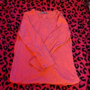 Korallfärgad långärmad tröja Lindex - Säljer en enkel och skön långärmad tröja från Lindex Kids i en snygg korallrosa färg. Tröjan har rund halsringning och är tillverkad i mjuk bomull. Passar dig som gillar basic och vill ha något som funkar till jeans eller leggings.