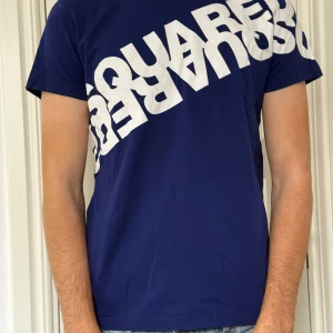 Blå Dsquared2 t-shirt med tryck - Hej, säljer nu min marinblåa t-shirt från Dsquared2 då den inte används längre. Den är äkta och i mycket bra skick använd ett fåtal gånger. Det är storlek 16y men är lite liten på mig jag är 190. Skriv vid frågor. Kan mötas i Stockholm/ Uppsala området. 