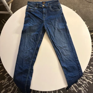 Blå slim fit jeans från Lee - Snygga blå jeans från Lee. Jeansen har slim fit passform, normal midja och är tillverkade i stretchigt denim med 99% bomull och 1% elastan.