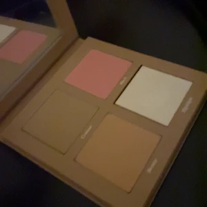 CAIA Face Palette Sassy - Snygg face palette från CAIA i färgen Sassy. Paletten innehåller fyra puder: en matt contour i beige, en peachy bronzer, en rosa blush och en skimrig highlighter i champagne. Perfekt för att skapa en fräsch och glowig look. Kommer i stilren beige förpackning med spegel. Helt ny!!! 