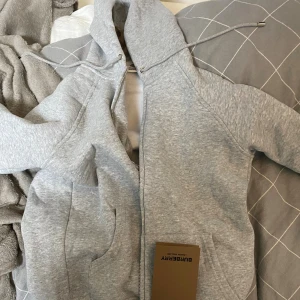 Grå burberry zipper - Säljer min riktigt fina, nya burberry zipper. Storlek M men passar inte bra därför väljer jag storlek att sätta den på storlek S. OBS Tar bara emot swish!!!!