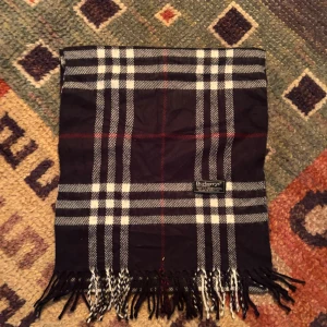 Vintage Burberry Halsduk - -Riktigt bra skick, knappt använd. Nypris på dessa ligger på runt 5000kr, vilket gör detta till ett sjukt bra pris! Halsduken är gjord i Lamull, och är perfekt inför hösten och den kommande vintern. Anledningen till att det står ”Burberry’s” och inte ”Burberry” på lappen är eftersom halsduken är från några år tillbaka, innan de bytte namn! Om du har någon fråga är det bara att skriva till mig. /elgnce (2)