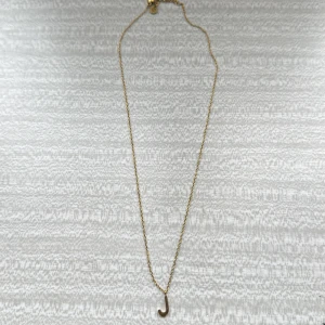 Guldigt halsband med J-berlock från Edblad - Snyggt och stilrent halsband i guldton från Edblad med en tunn kedja och en liten berlock i form av bokstaven J. Perfekt för dig som vill ha något personligt och enkelt. Kedjan har en diskret Edblad-tag vid låset.