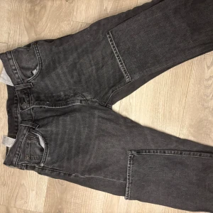 Levi's 551 svarta jeans W30 L32 - Svarta Levi's 551 jeans med klassisk femficksdesign och snyggt tvättad finish. Jeansen har rak passform och är tillverkade i robust denim. Perfekta för dig som gillar en tidlös och avslappnad stil.