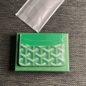 Grön plånbok med mönster - Snygg grön plånbok från  med deras ikoniska grafiska mönster i vitt och grönt. Plånboken har flera kortfack och en insida i orange. Perfekt för dig som vill ha något unikt och trendigt i fickan.