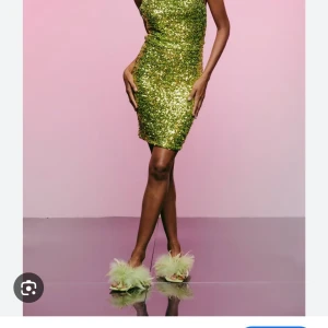 Glittrig grön kortklänning - Säljer en glittrig grön kortklänning med figurnära passform och ärmlös design. Klänningen har massor av paljetter som ger en riktigt festlig vibe och sticker ut i mängden. Perfekt för dig som vill glänsa och synas på nästa event! Aldrig använd prislapp kvar! 