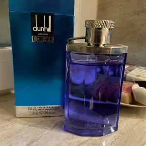 Dunhill Desire Blue – Eau de Toilette (100 ml) - Fräsch, stilren och självsäker – Dunhill Desire Blue är doften för mannen som vill känna sig fräsch och avslappnad men ändå utstråla klass. Den ger en modern och ren känsla som passar perfekt till både kontoret och kvällens planer. kommer med originalförpackning. Nypris ca 700 kr – säljes för 299 kr. Med cirka 90% kvar av flaskan!