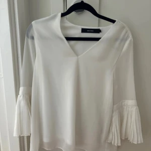 Vit blus med plisserade ärmar Vero Moda - Säljer en vit blus från Vero Moda med v-ringning och plisserade detaljer på ärmarna. 