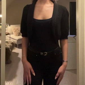 Svart stickad cropped kofta - Snygg svart stickad kofta med korta ärmar och croppad passform.